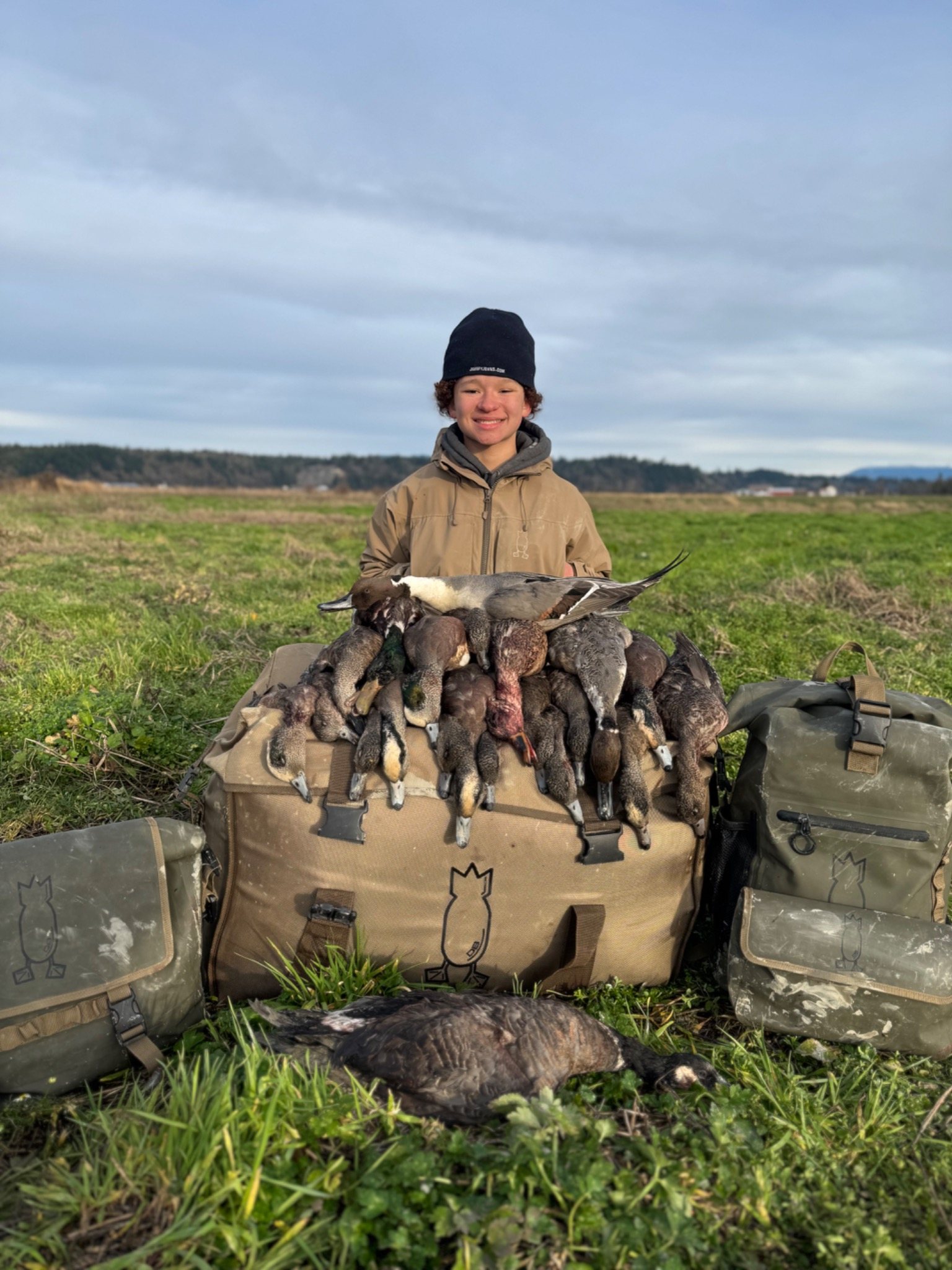 Young hunter with ducks in a field